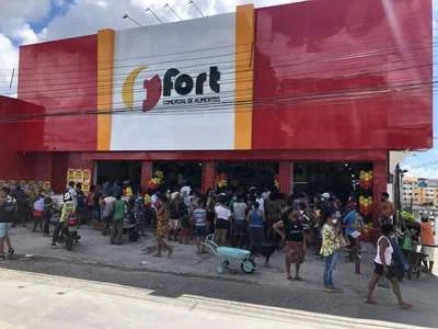 Inauguração do supermercado Fort com fachada vermelha e movimento de clientes