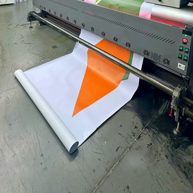 Lona impressa saindo da impressora de bobina na fábrica da COMUNIKAR